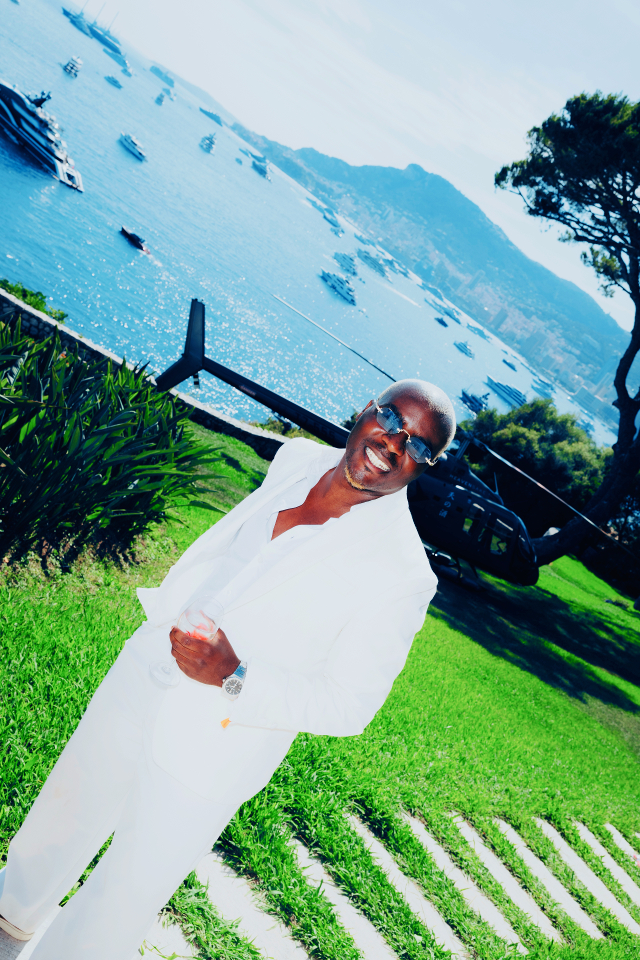 Lucien Ndabagera in a garden above Monaco with a helicopter behind him